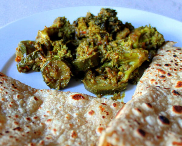 Broccoli and Zucchini in Onion and Pickle Spices served on a plate with roti