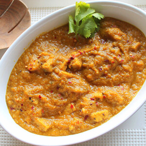 Mango curry tempeh in a white serving bowl