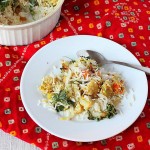 A white plate with layered rice and veggies on a red fabric
