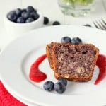 Two slices of blueberry Apple Whole Grain Cake served with fresh blueberries and a red sauce