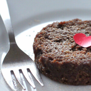 A closeup of chocolate cake on a white plate with a fork