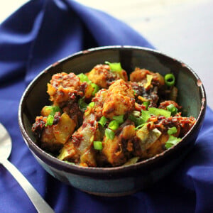 Keralan Tempeh Chili Roast in a black bowl on a blue cloth