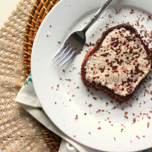 A slice of French toast on a white plate with a fork. Sprinkled with cocoa powder