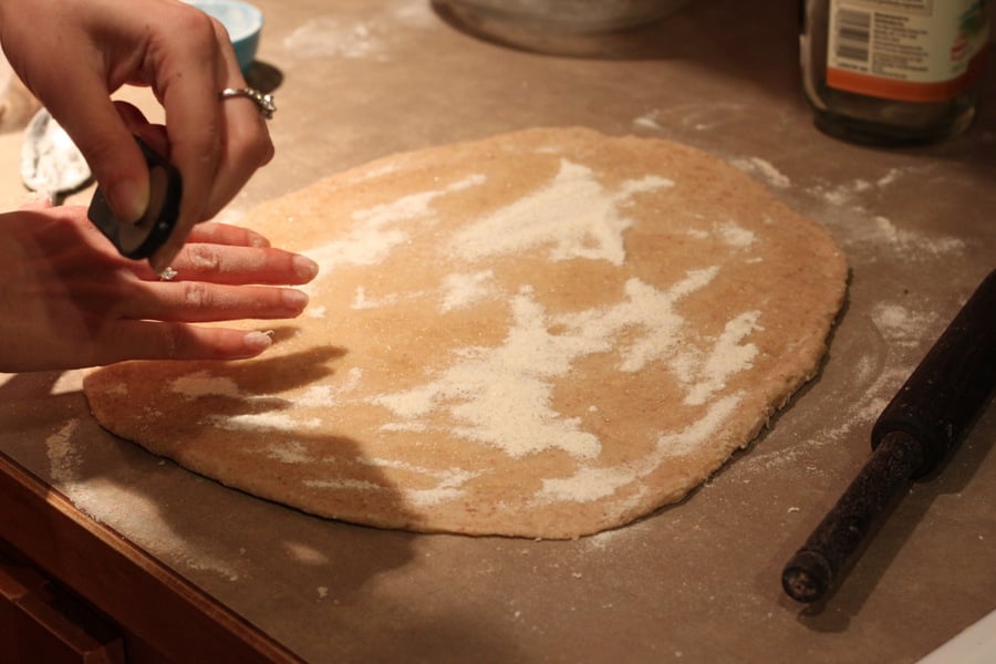 vegan cinnamon rolls granulated sugar being sprinkled on rolled out cinnamon roll dough