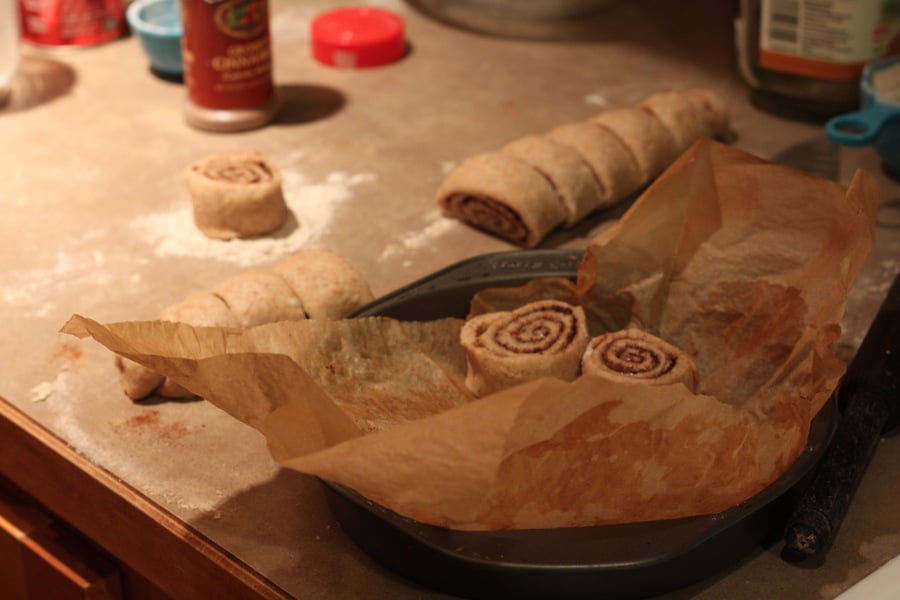 vegan cinnamon rolls unbaked vegan cinnamon rolls being placed into a round cake pan