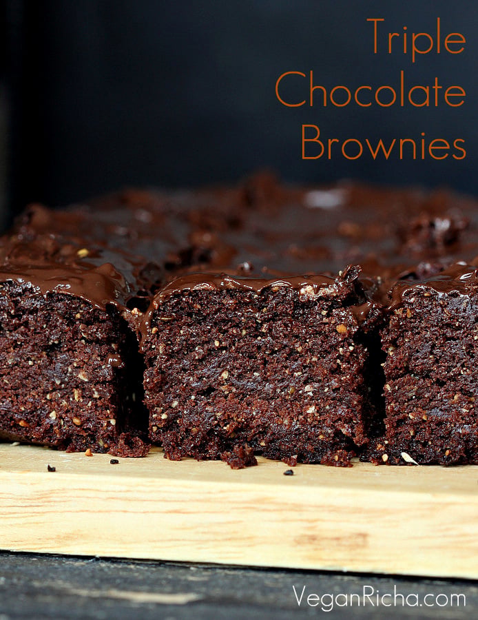 salted caramel brownies side view of Vegan Triple Chocolate Salted Caramel Brownies on a wooden board
