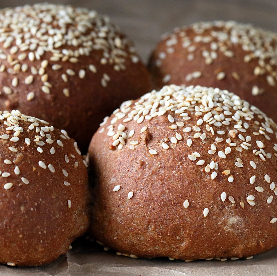vegan burger buns side view close-up of Rye Almond Flour Vegan Burger buns sprinkled with sesame seeds