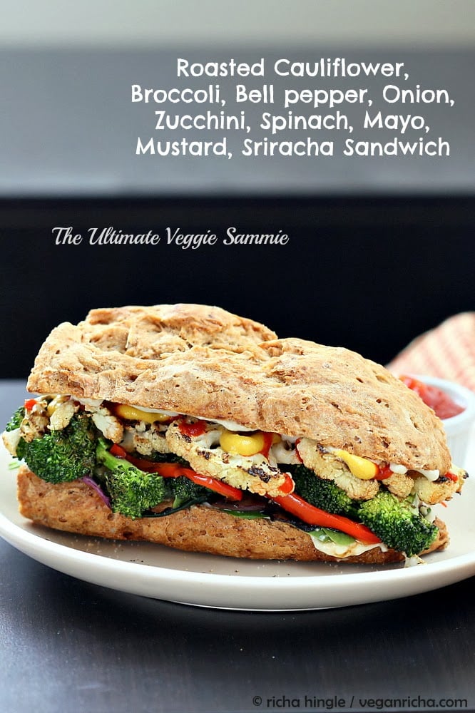 vegetable sandwich side view of a vegan roasted vegetable sandwich made with grilled broccoli, cauliflower, bell pepper and sriracha mayo