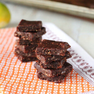 No bake chocolate bars stacked on a piece of orange fabric
