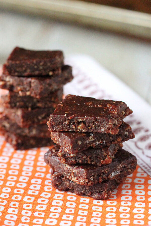 No bake chocolate bars stacked on a piece of orange fabric