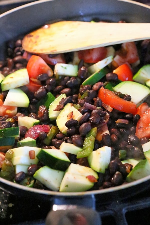 vegan wrap recipe vegetarian filling for a vegan wrap recipe being sauteed in a black pan