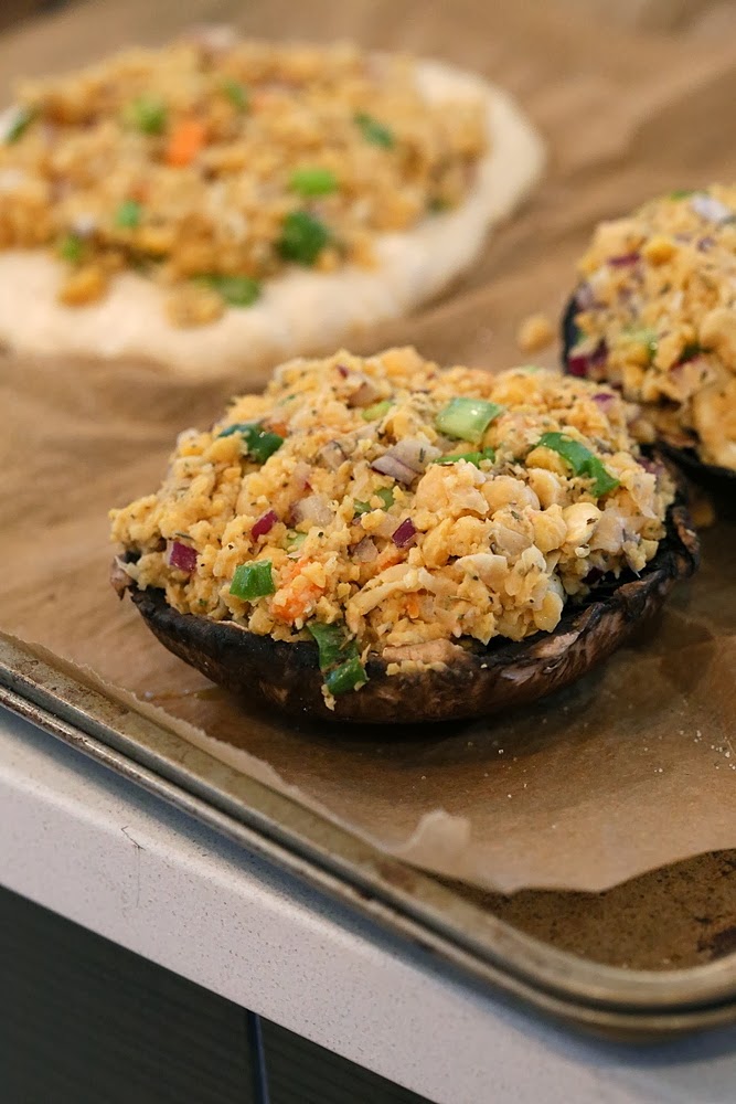 stuffed Portobello mushrooms Vegan stuffed Portobello mushrooms with chickpea filling lined up on a baking sheet