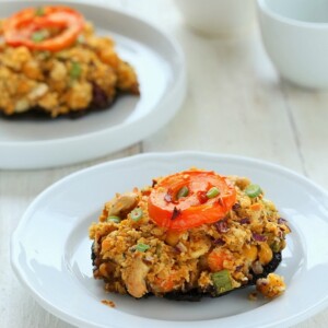 side view of vegan stuffed Portobello Mushrooms on a white plate