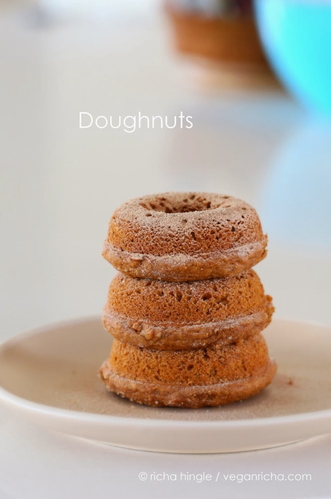 recipe for vegan donuts three cinnamon sugar-dusted vegan baked sweet potato donuts on a white plate