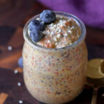 carrot cake overnight oats in a jar with blueberries on top