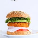 Spicy Chickpea Burger with toppings on sesame seed bun on a white plate