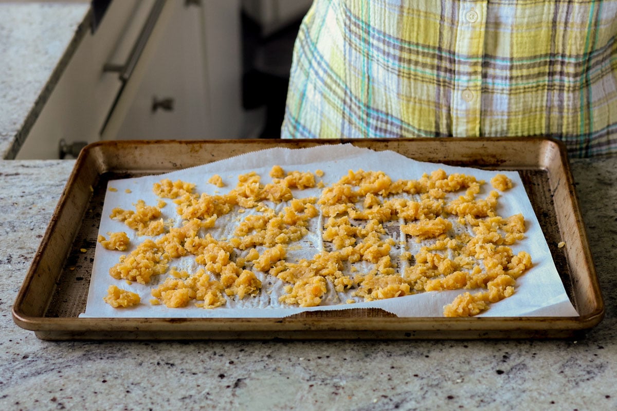 red lentil granola spread out on the baking pan, before baking