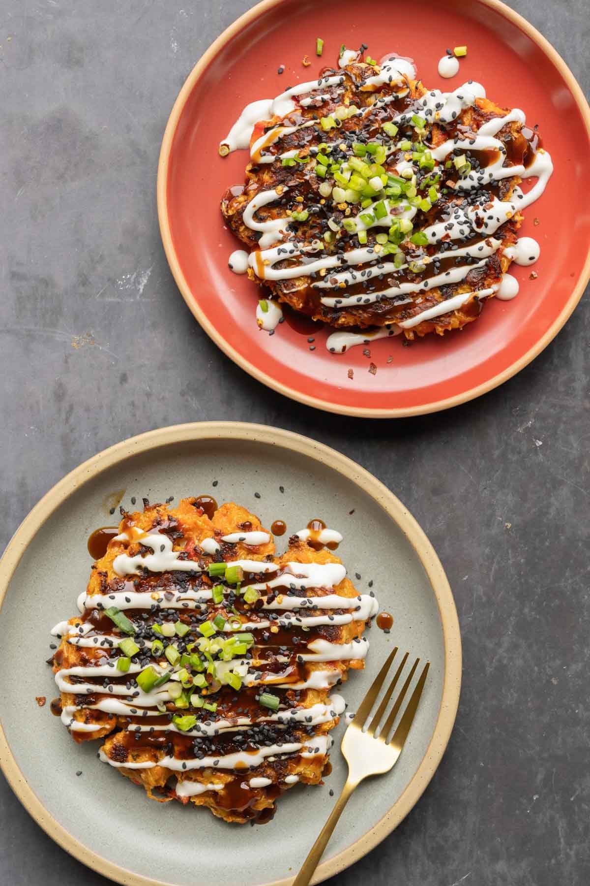 plates of Japanese cabbage carrot pancakes with sauces and green onion