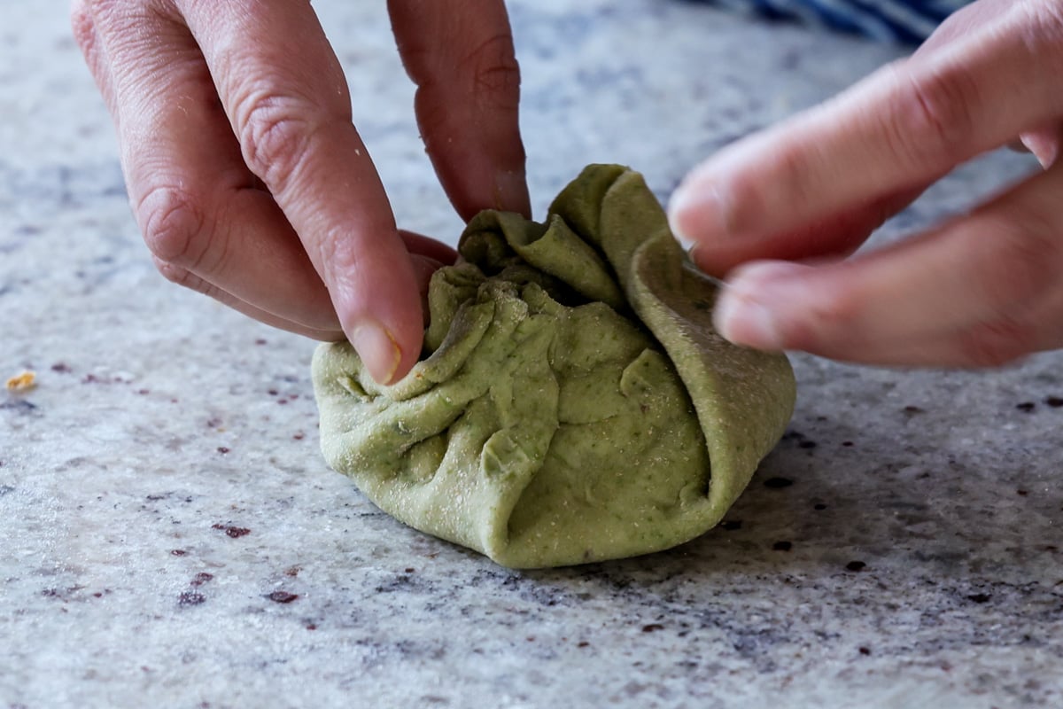folding the spinach mixture into the dough