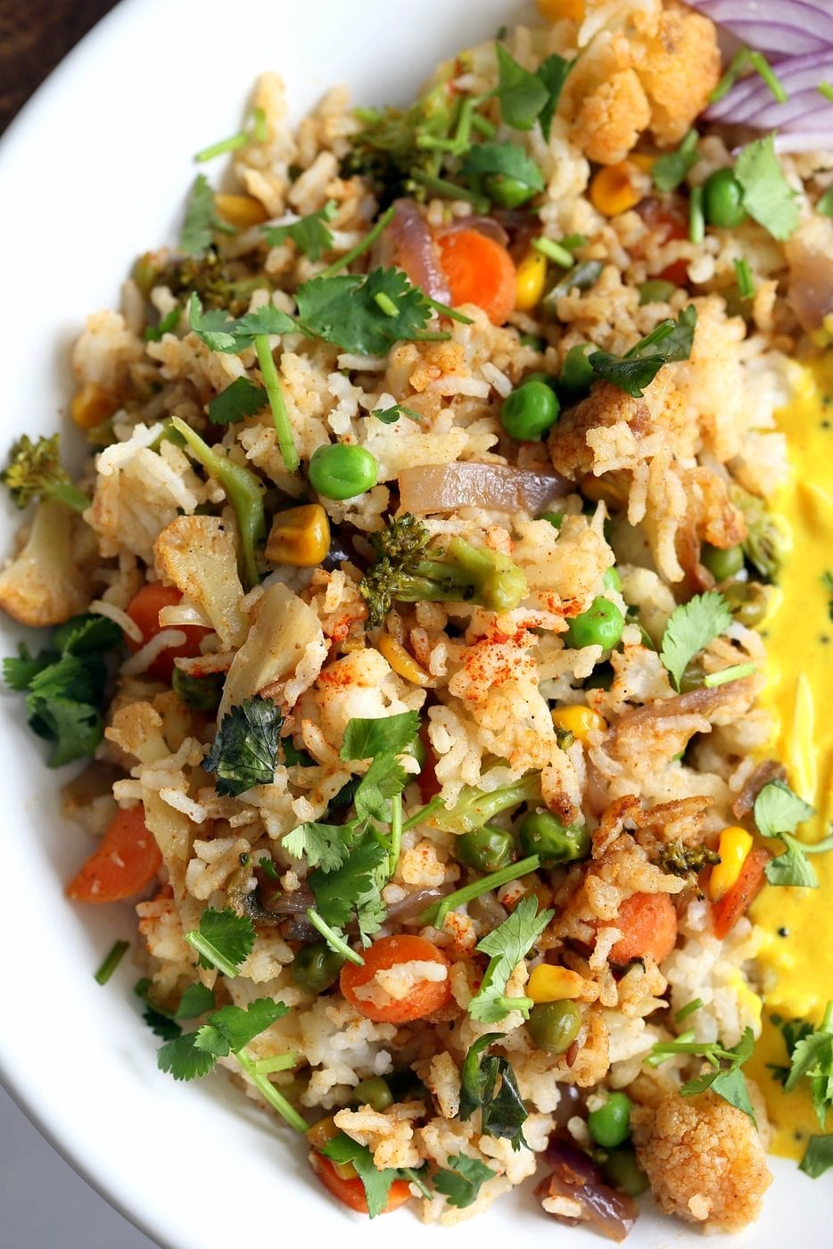 Indian Spiced Masala Veggie Fried Rice with Turmeric Onion Raita. Use up the leftover rice or grains to make this quick spiced fried rice and serve with a simple yogurt raita that is spiced with turmeric and mustard seeds. Vegan Gluten-free Soy-free Indian Recipe | VeganRicha.com