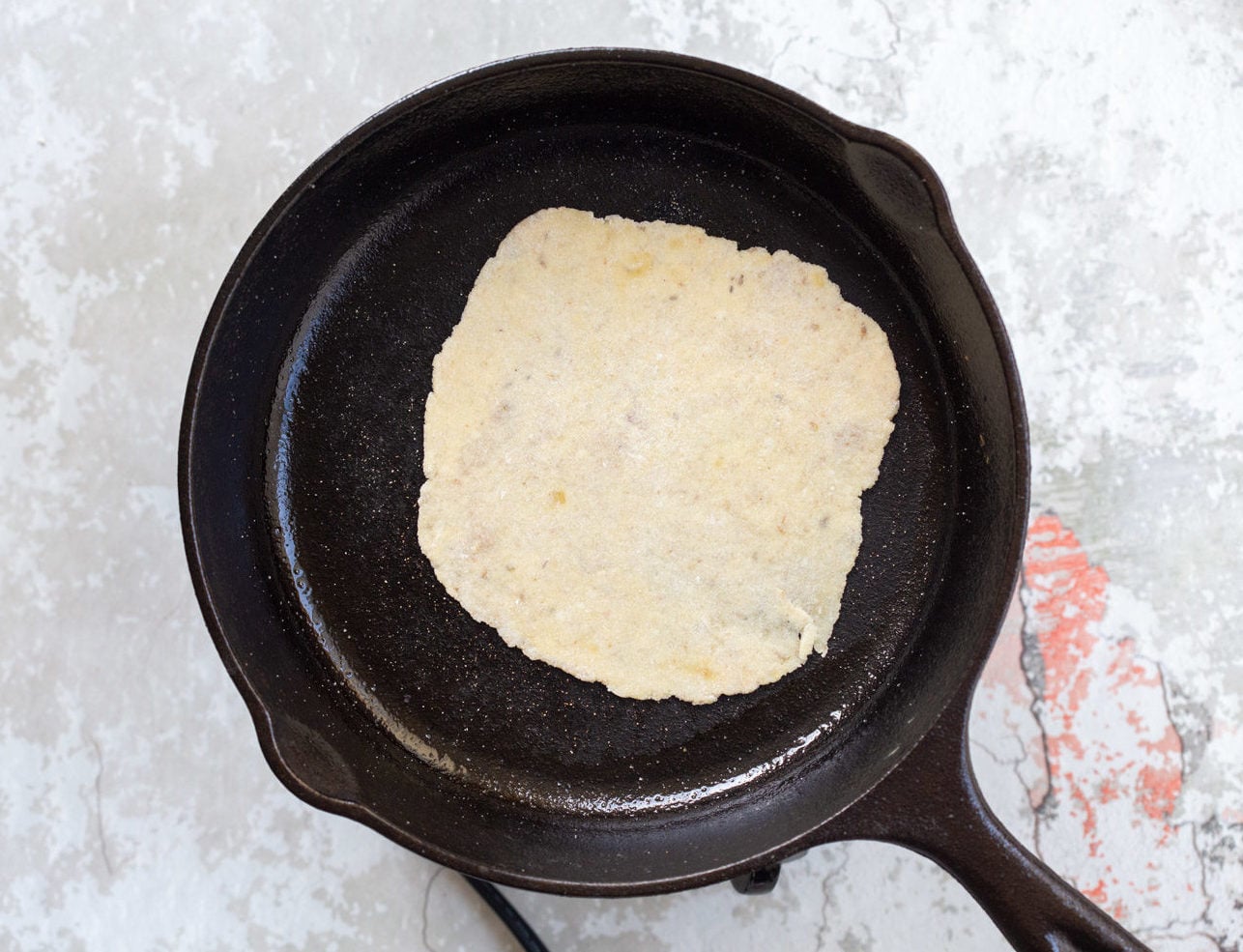 Gluten free Cauliflower Flatbread getting cooked on a cast iron skillet