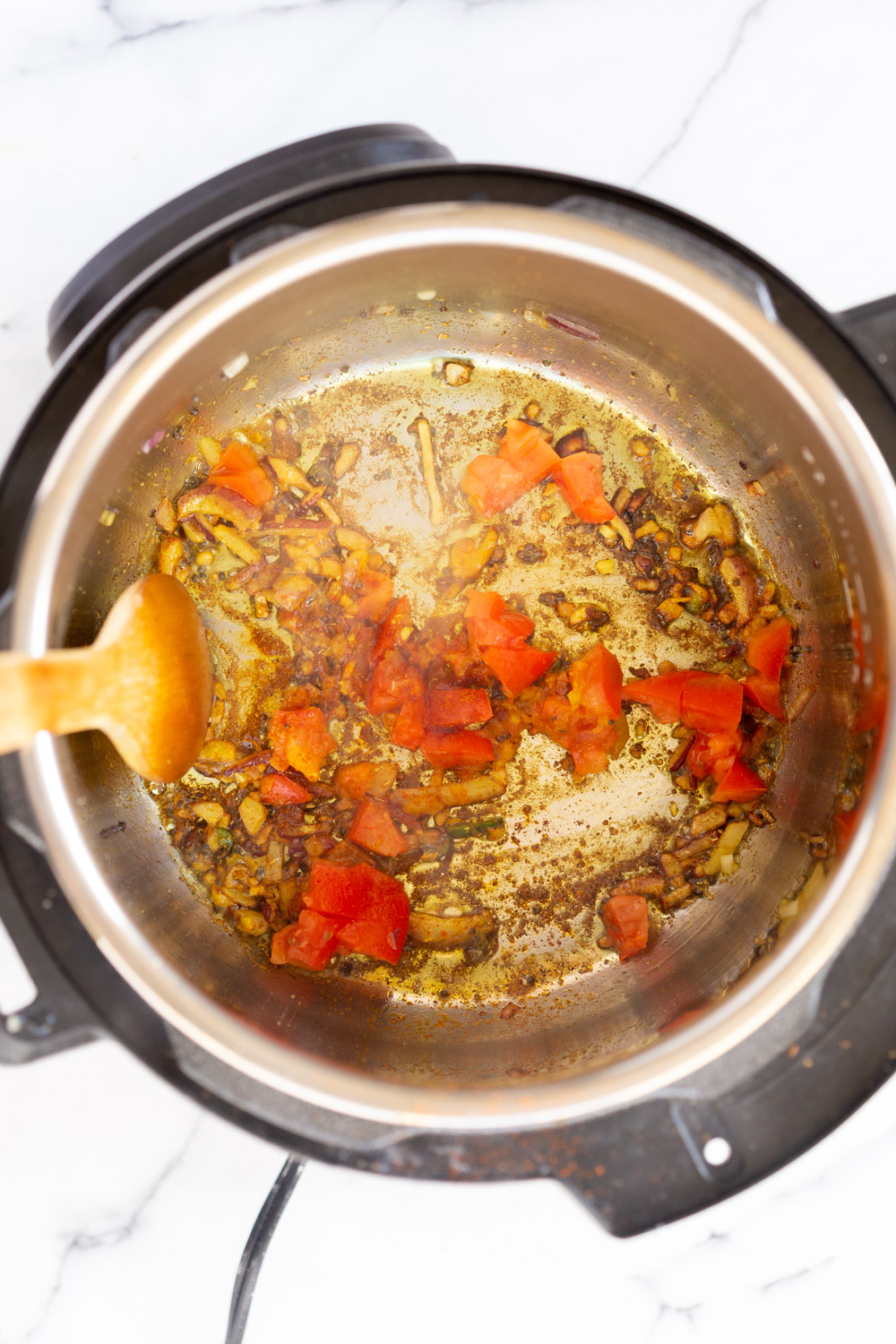 Instant Pot Kitchari onions, garlic and spices being fried in an Instant Pot to make Kitchari