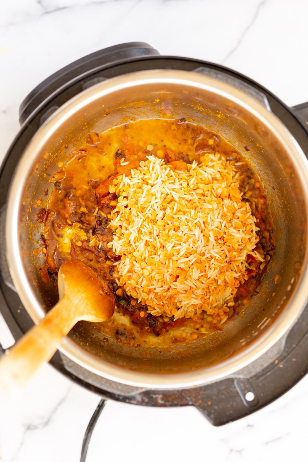 Instant Pot Kitchari soaked rice and lentils being added to Instant Pot to make Kitchari
