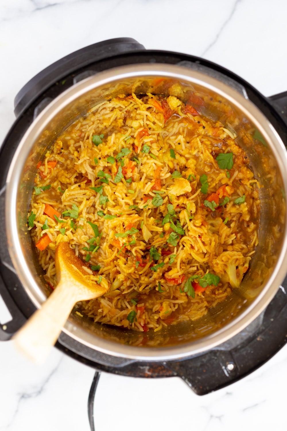 Instant Pot Kitchari fresh cilantro being sprinkled on top of kitchari