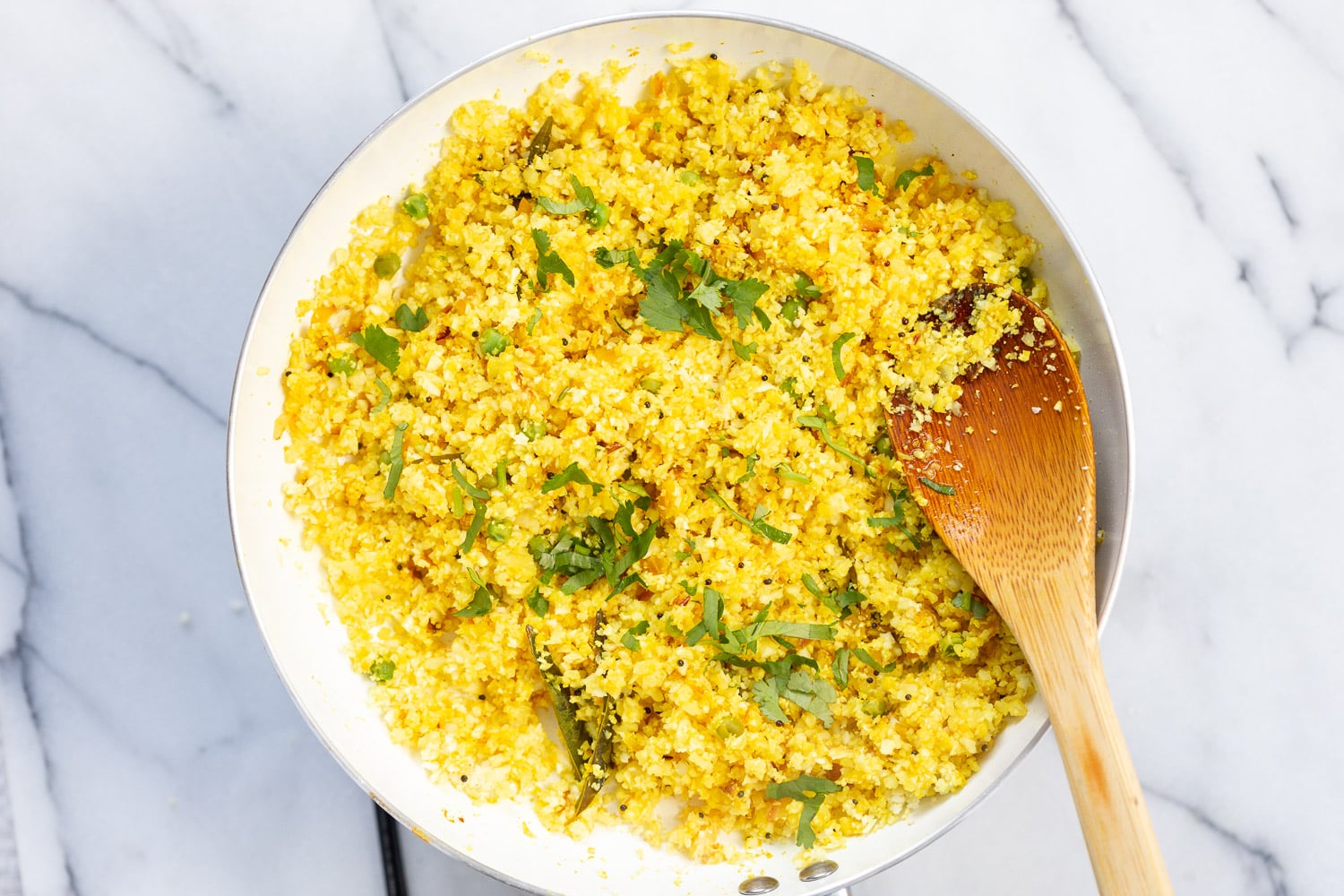 Our Turmeric Cauliflower Rice cooked in a white skillet