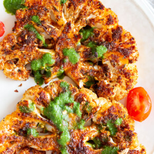 Vegan Cajun Roasted Cauliflower "Steaks" with Chimichurri Sauce. Slice into thick slices or just chop into florets to make this delicious Cajun Cauliflower. Serve with chimichurri or a cooling dressing. #Vegan #Glutenfree #Soyfree #Nutfree #Recipe #veganRicha #cajunCauliflower