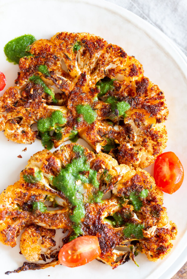 Vegan Cajun Roasted Cauliflower "Steaks" with Chimichurri Sauce. Slice into thick slices or just chop into florets to make this delicious Cajun Cauliflower. Serve with chimichurri or a cooling dressing. #Vegan #Glutenfree #Soyfree #Nutfree #Recipe #veganRicha #cajunCauliflower