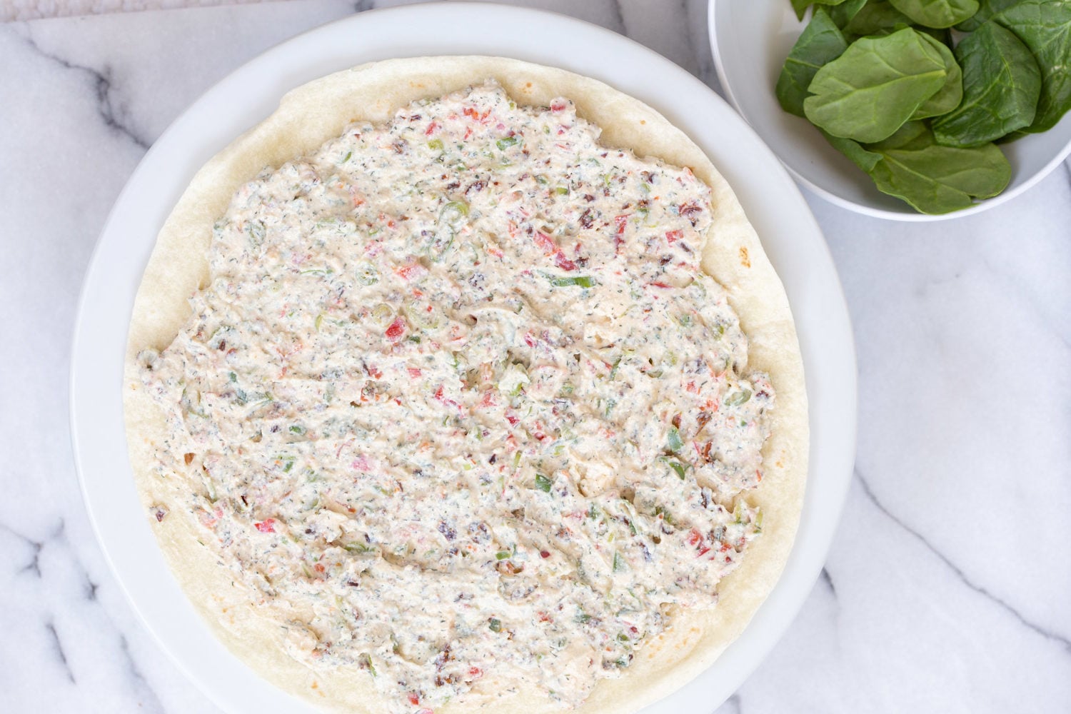 Dairy free Veggie Cream Cheese spread on tortilla for our Vegan Tortilla Roll ups recipe