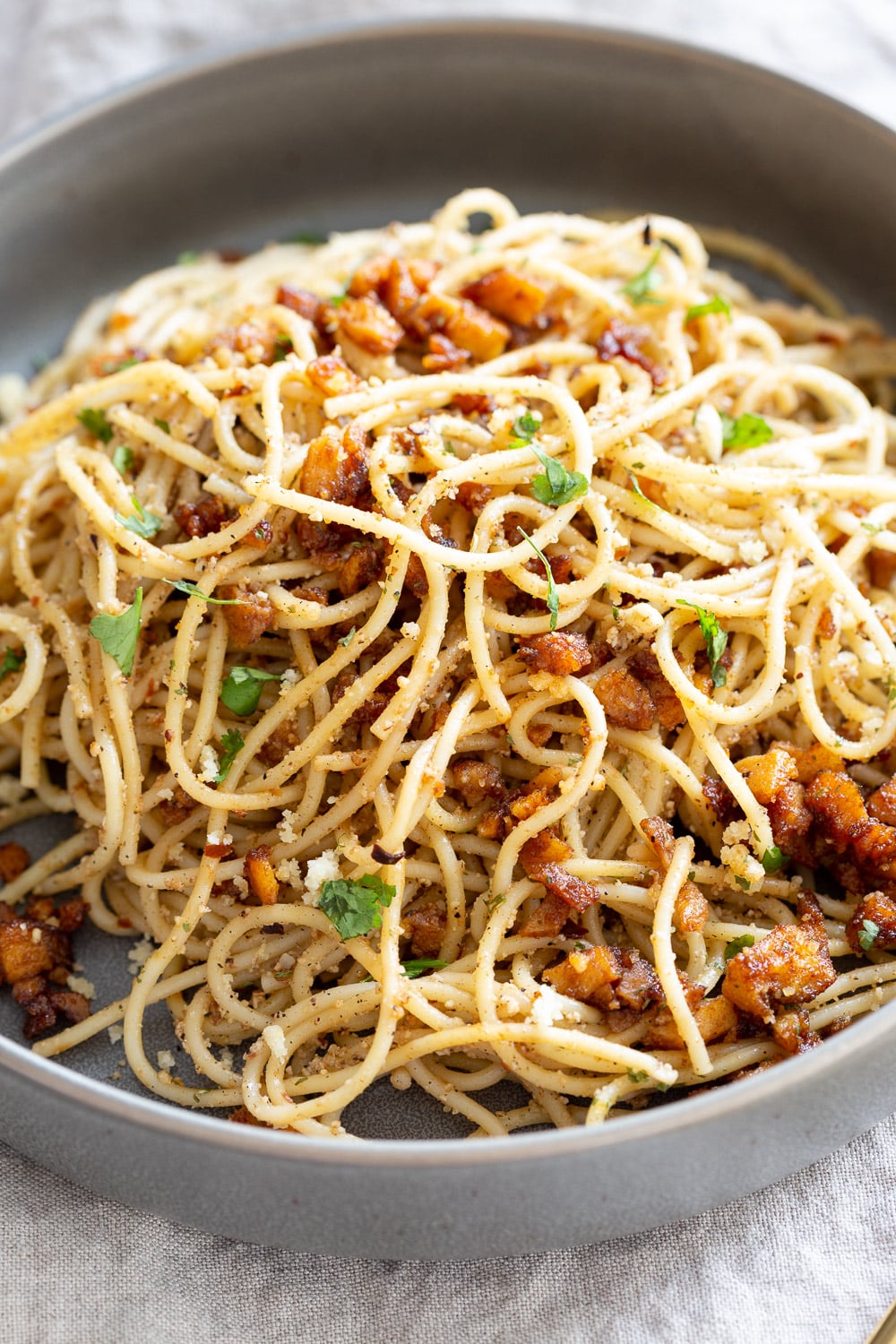Vegan Cacio e Pepe with Smoky Balsamic Roasted Chickpea tofu in a grey bowl