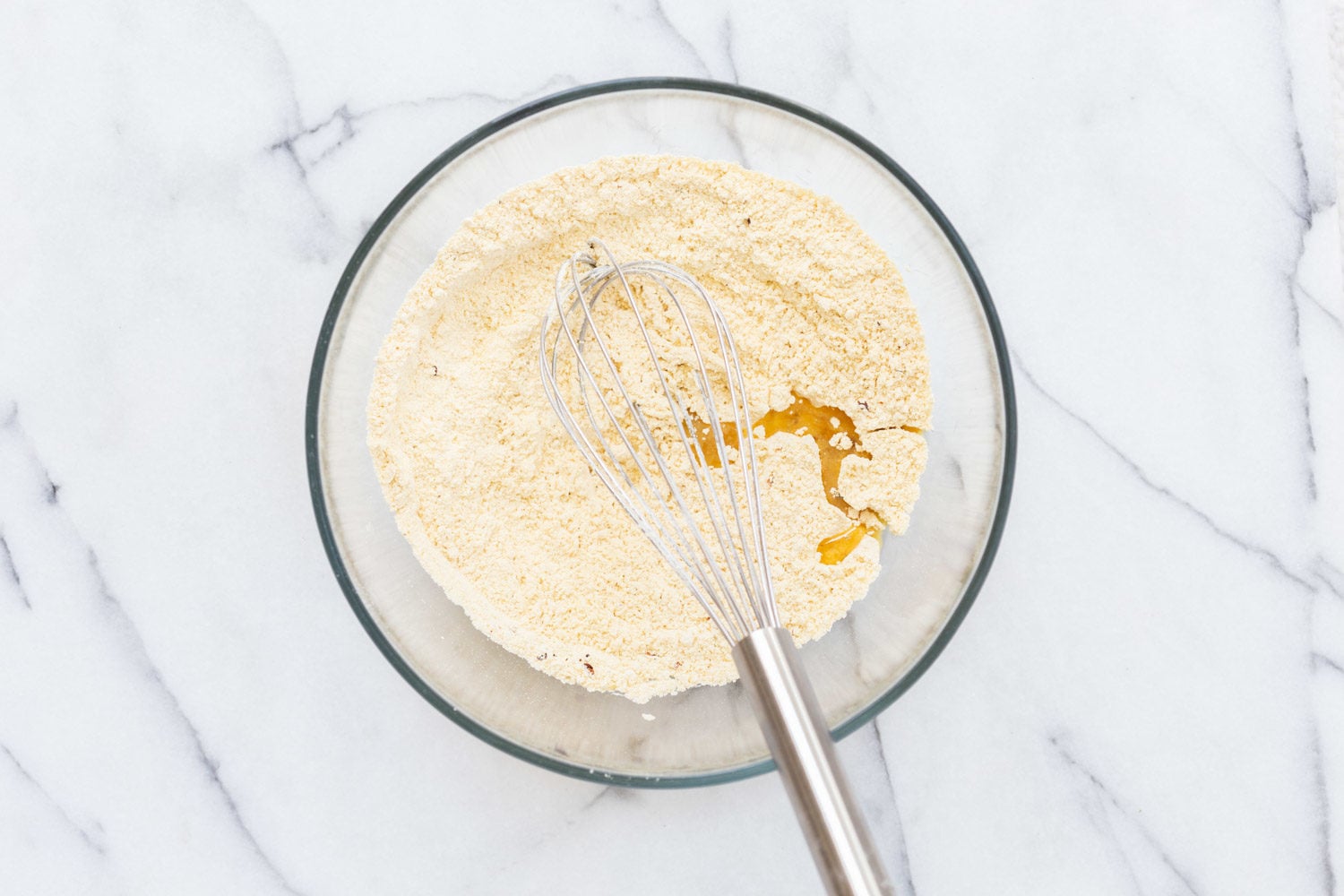 Chickpea flour and oil in a glass bowl for our Vegan Socca