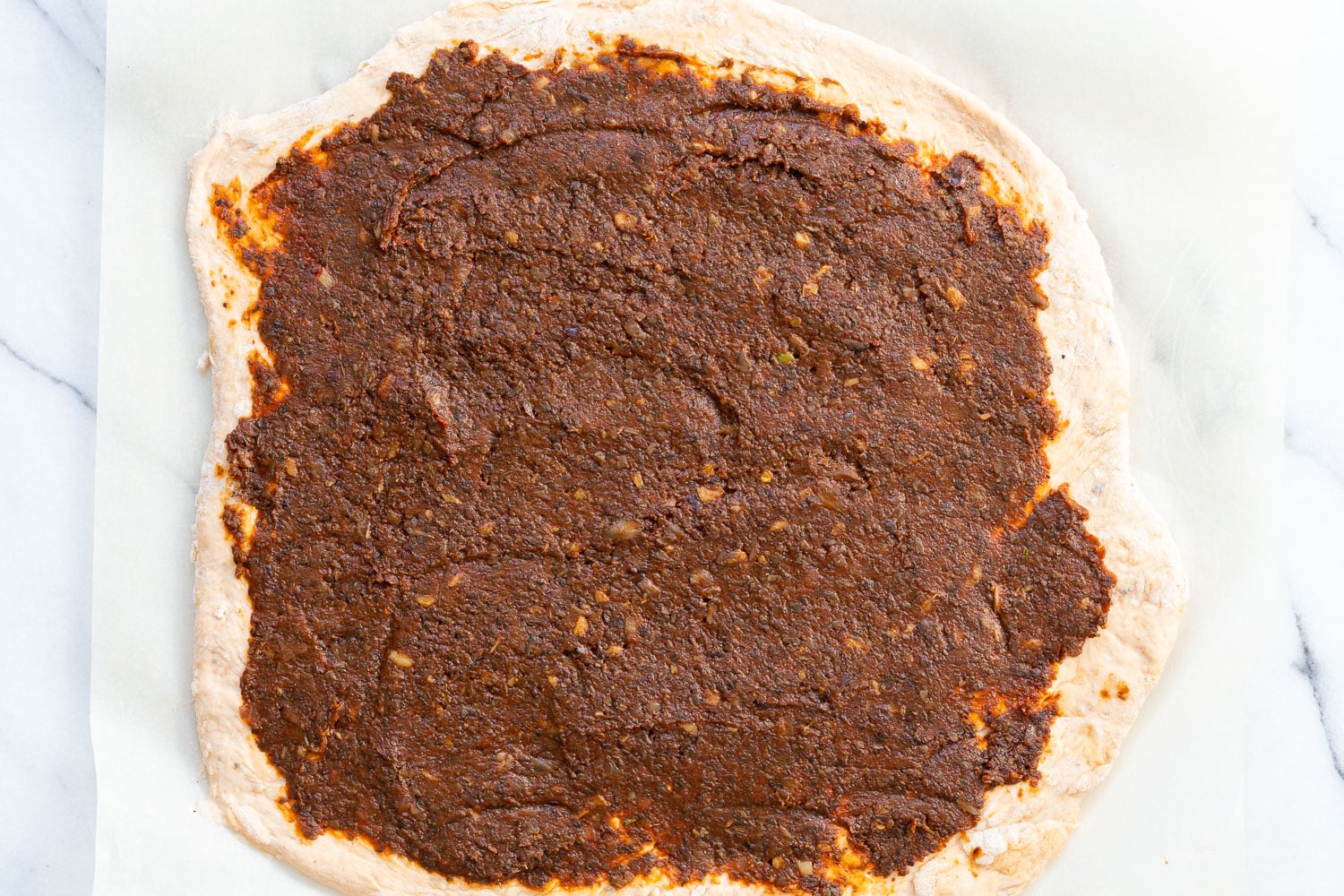 Filling spread on dough for our Vegan Pizza Rolls