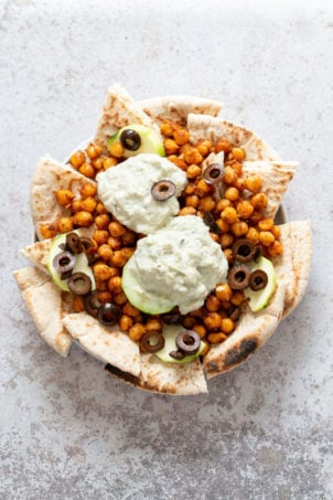 Vegan Mediterranean Nachos with Shawarma Chickpeas, Tzatziki, Olives, Cucumber, warm toasted Pita bread. Great Appetizer for parties or potluck. #Vegan #Veganricha #Mediterraneannachos