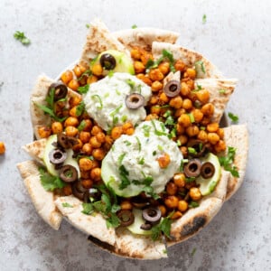 Mediterranean Nachos with Shawarma Chickpeas, Tzatziki, Olives, Cucumber, warm toasted Pita bread. Great Appetizer for parties or potluck. #Vegan #Veganricha #Mediterraneannachos