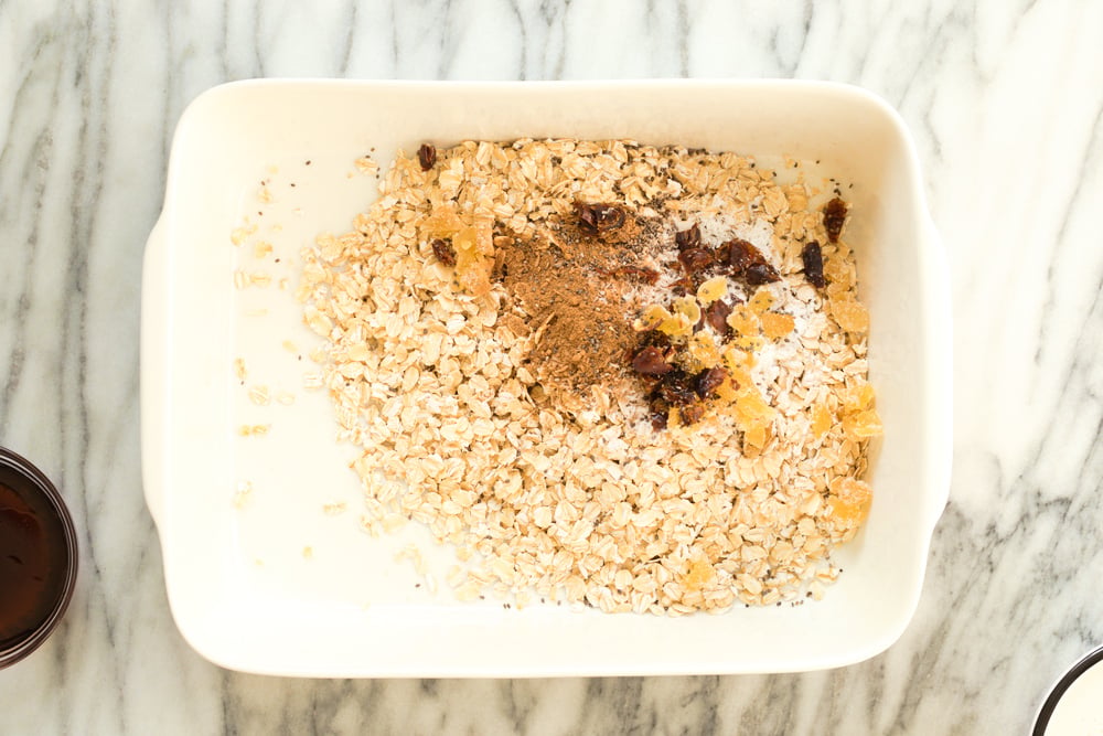 Dry ingredients for Vegan Gingerbread Baked Oatmeal in a white baking dish