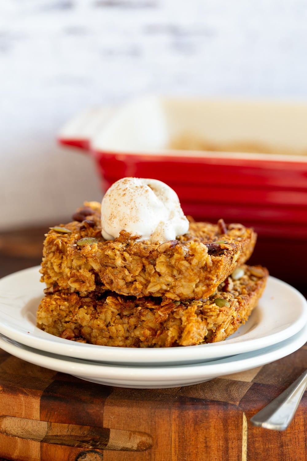 Our Vegan Pumpkin Baked Oatmeal on white plate on a wood cutting board