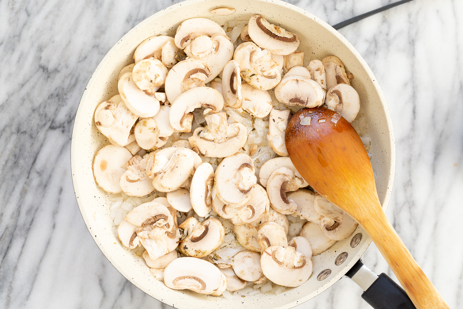 onion and mushrooms in a white skillet