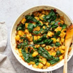 Garlic Potato Spinach Stir fry in a white skillet