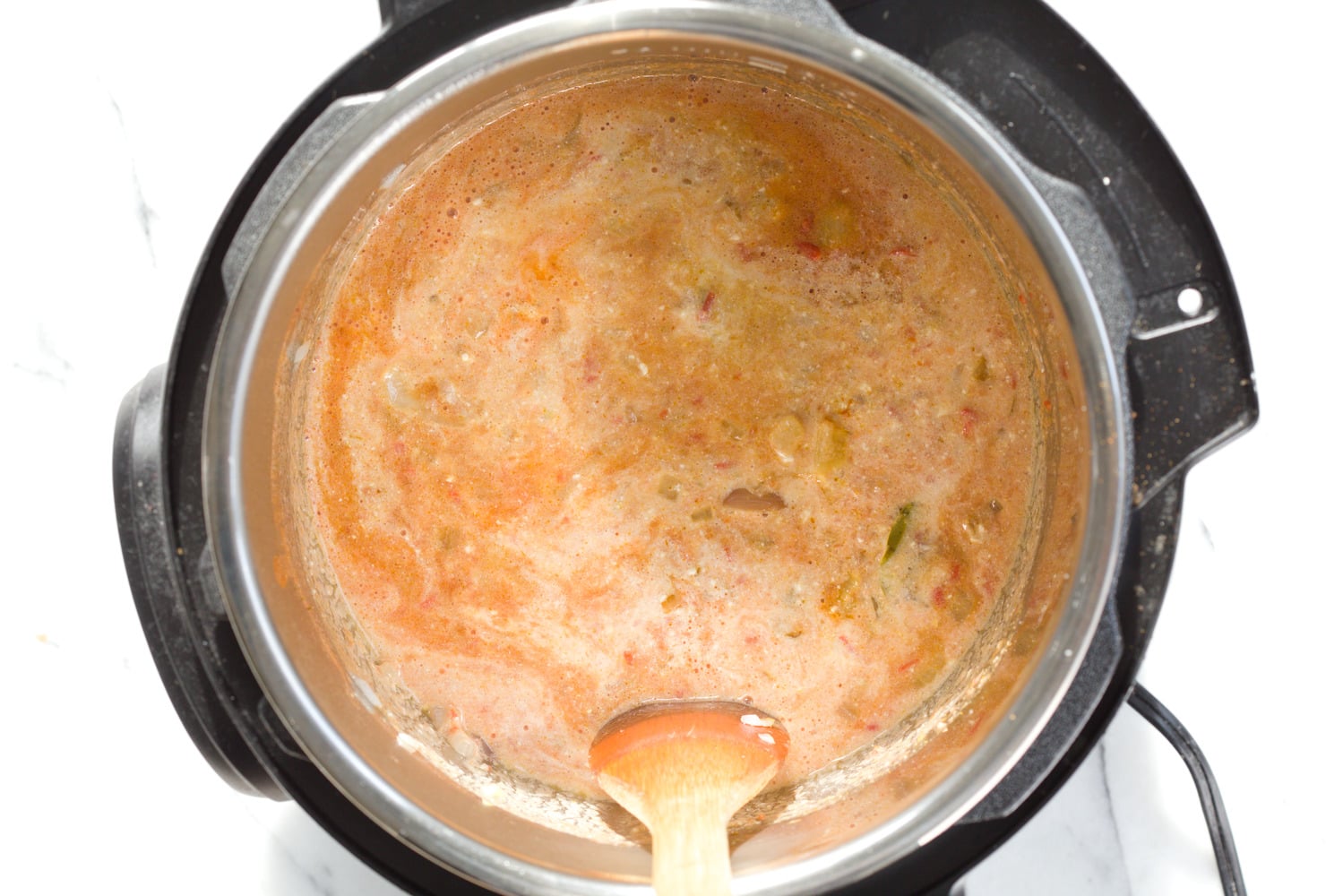 vegan curry recipe dairy-free milk being stirred into a vegan fenugreek chicken curry made with soy curls