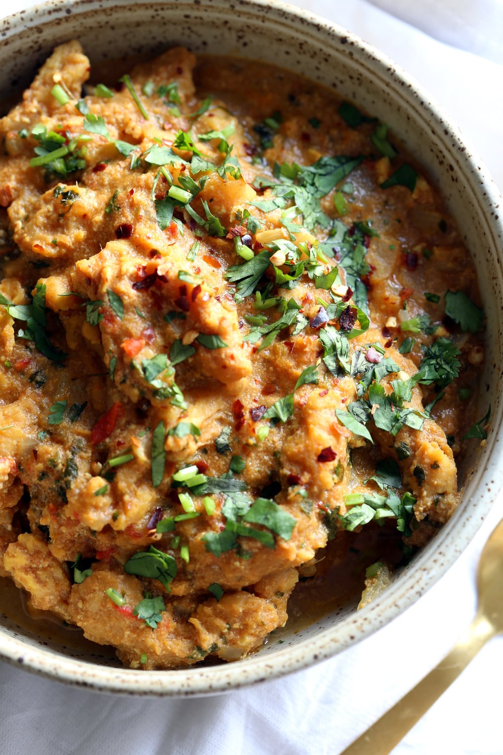 vegan curry recipe overhead shot of a bowl of vegan fenugreek chicken curry topped with chopped cilantro