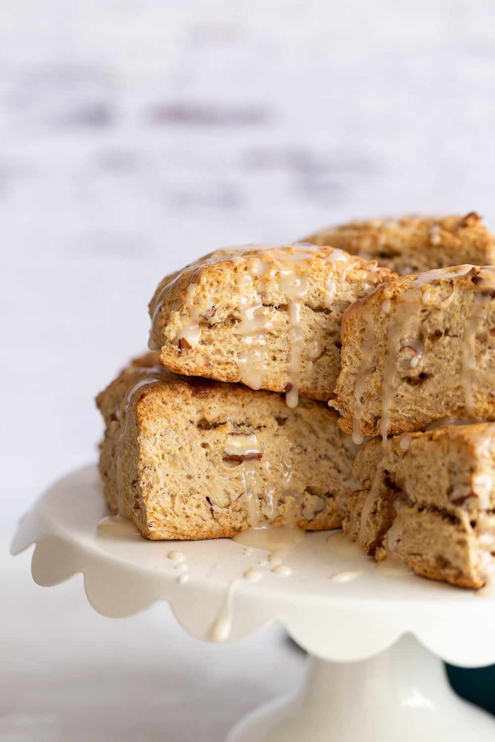 close up side view of vegan banana scones on a white cake stand