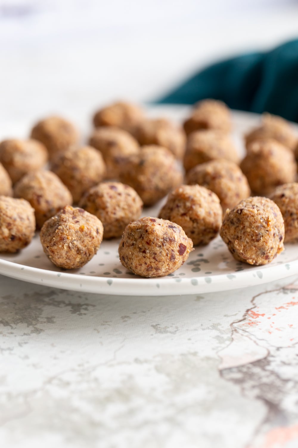 coconut balls side view of a plate with vegan coconut caramel date energy balls