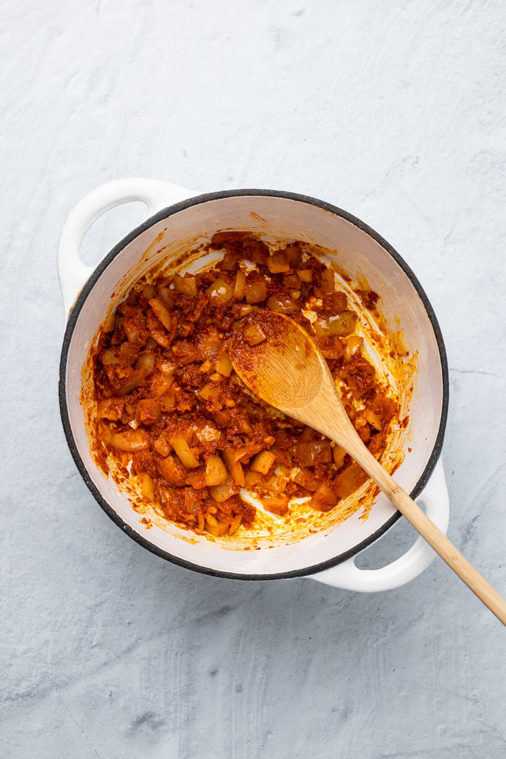 onions being sauteed with red curry paste 