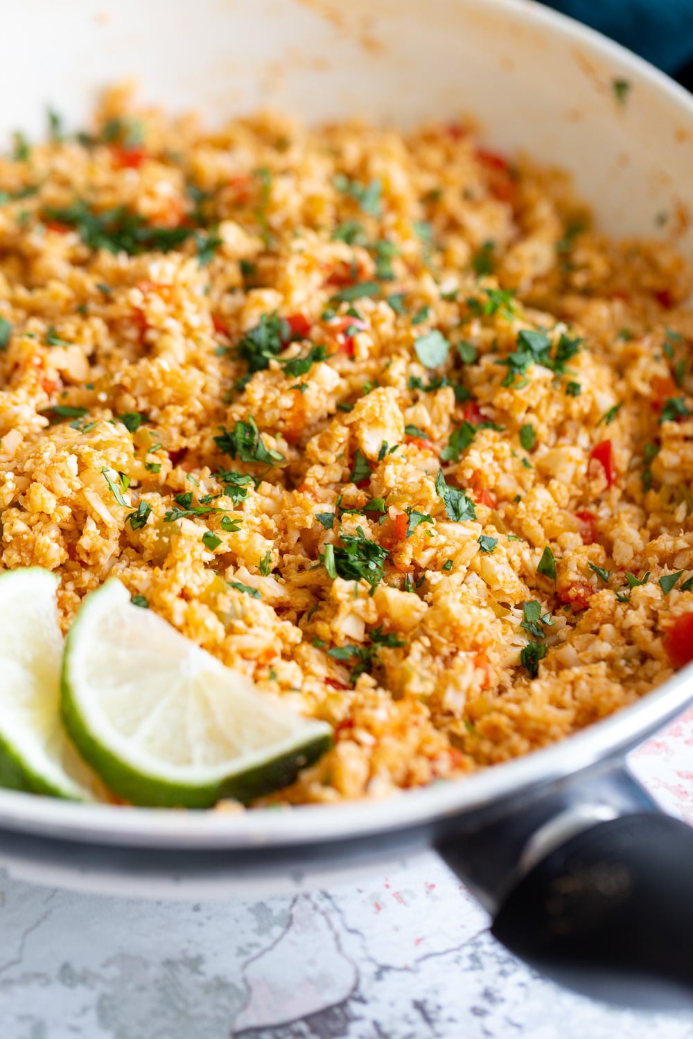 Spanish Cauliflower Rice side view of healthy vegan Spanish cauliflower rice in a pan