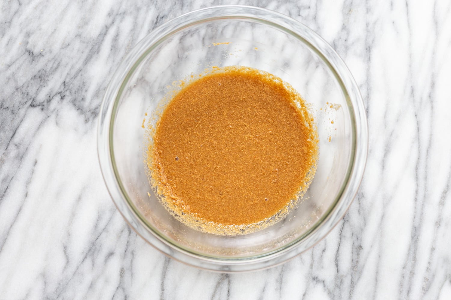 snickers recipe melted peanut butter heated with plant-based milk in a small glass bowl