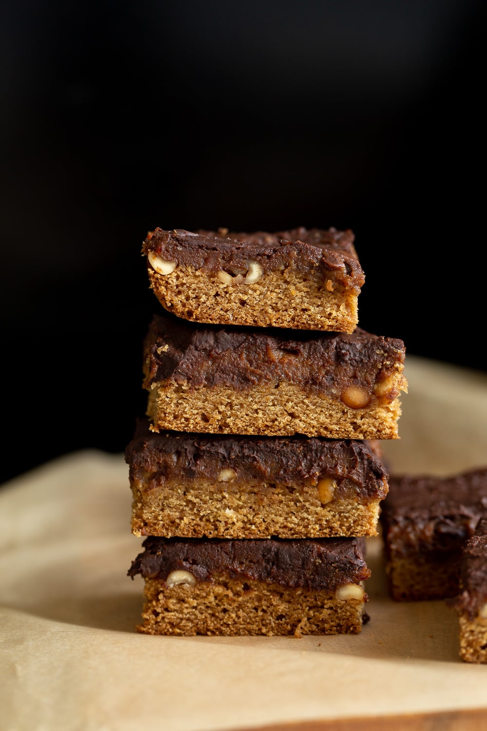 snickers bar recipe side view of a stack of healthy homemade vegan snickers bars with date caramel