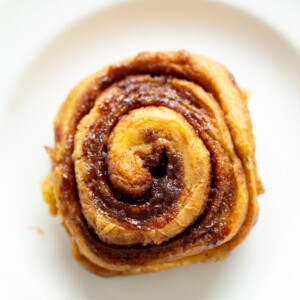 overhead shot of a vegan no yeast cinnamon roll with sweet potato on a white plate
